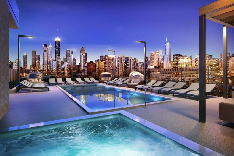 Rooftop hot tub and pool lounge area with panoramic city skyline views